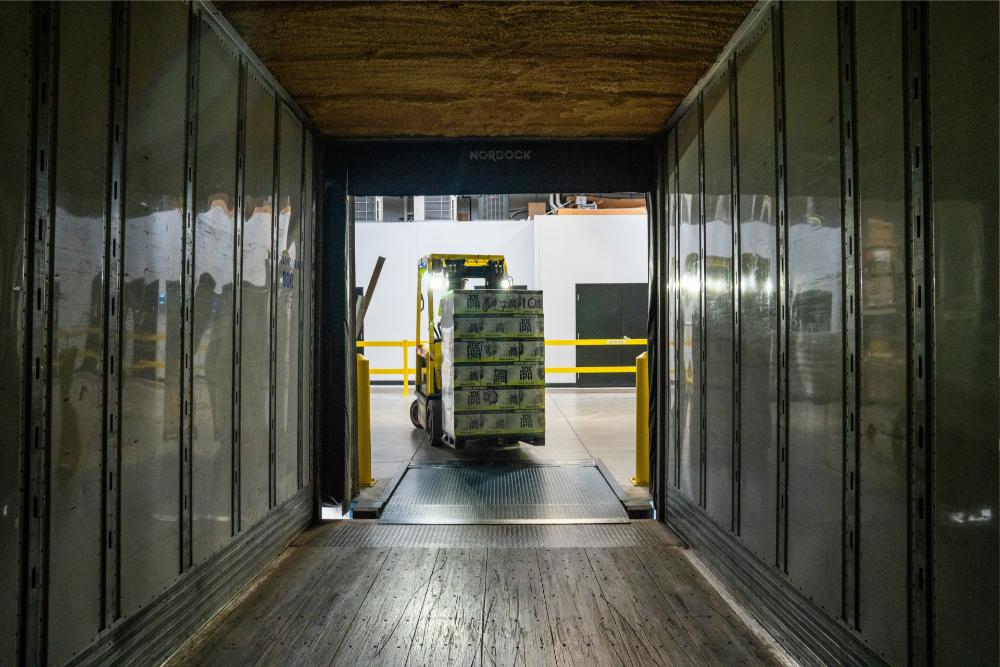 forklift loading a pallet of boxes in a warehouse