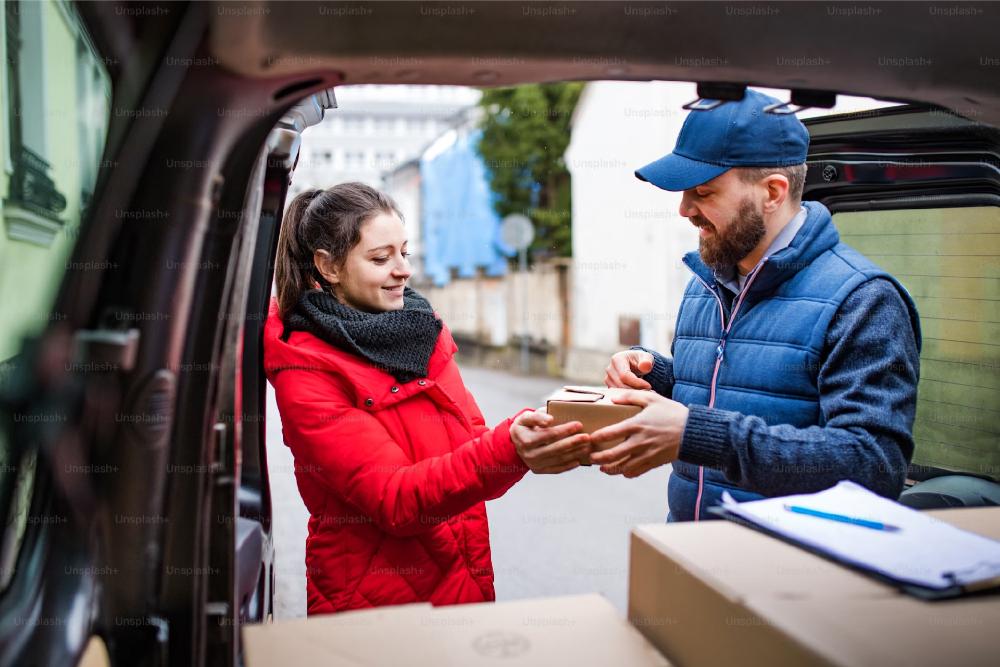 Woman receiving box delivered by worker